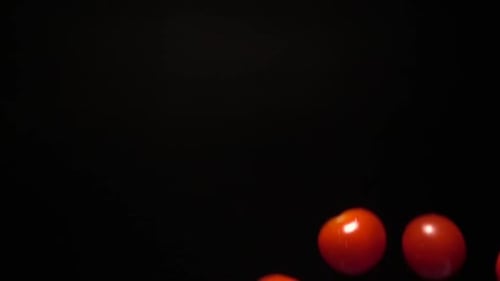Super Slow Motion of Cherry Tomatoes Flying Into the Air with a Splash of Water
