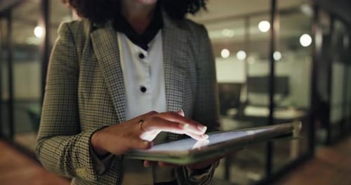Woman in office uses tablet at night