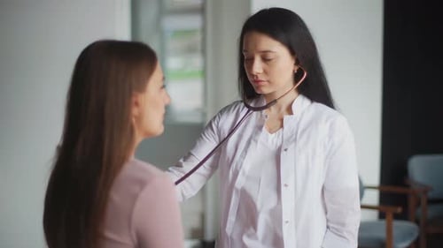 Doctor Examining Patient with Stethoscope in Clinic