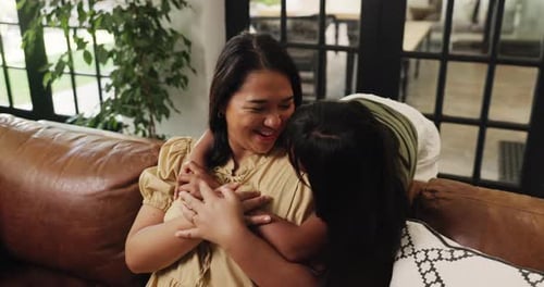 Happy Woman Hugged by Child on Brown Couch
