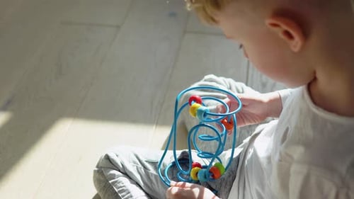 Little Boy Playing Education Logical Toy on the Floor in Nursery