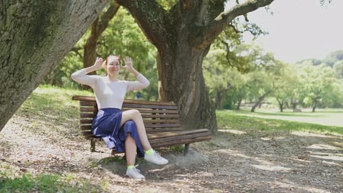 Playful Woman Making Silly Faces on a Park Bench