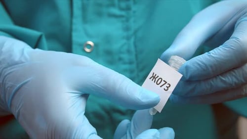 Medical Professional Examining Labeled Vial in Lab