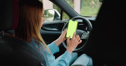 Close up Woman hands holding mobile telephone with vertical green screen in car chroma key smartphon