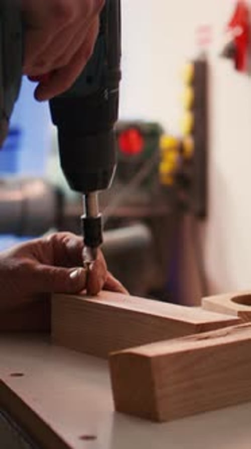 Vertical Video Carpenter Sinks Screws Into Wooden Surfaces with Power Drill Close Up