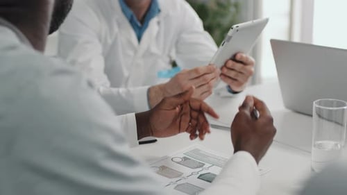 Doctors Reviewing Data and Tablet in Office