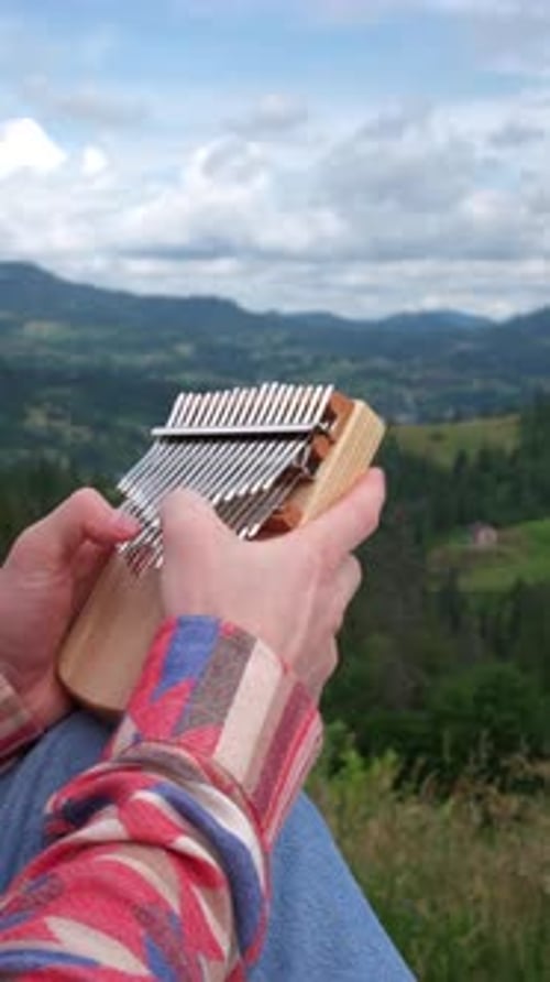 Person Playing Kalimba on Mountain Top
