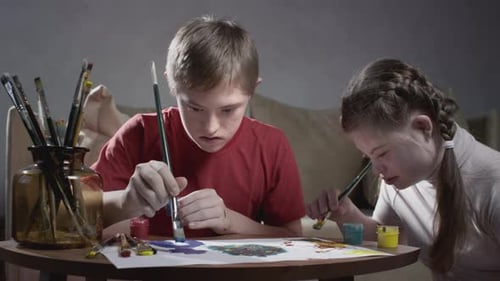 Children Painting Together at Table Indoors