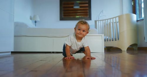Smiling Baby Crawling on Floor in Bright Bedroom
