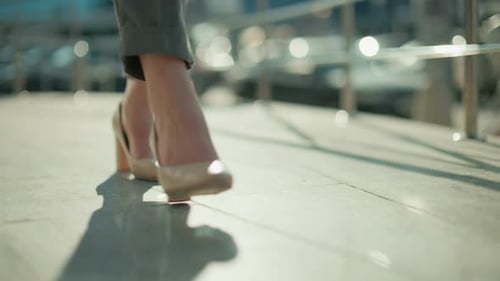 Close Up Legs of Woman in Heels Walking By Railing with Urban Background