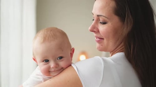 Smiling Infant Held By Smiling Mother