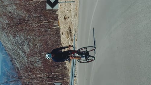 Cyclist Rides Bicycle on Mountain Road Turn