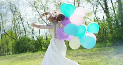 Woman in White Dress Twirling with Balloons