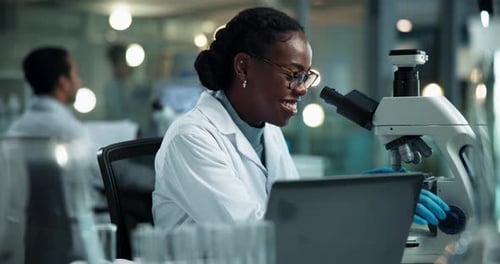 Female Scientist Works with Microscope in Modern Lab