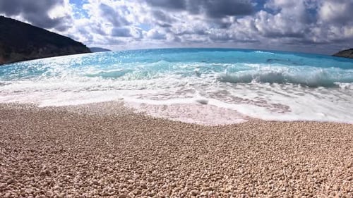 Sunlit Crystal Blue Sea Surrounding White Pebble Shores of Myrtos Beach, Kefalonia