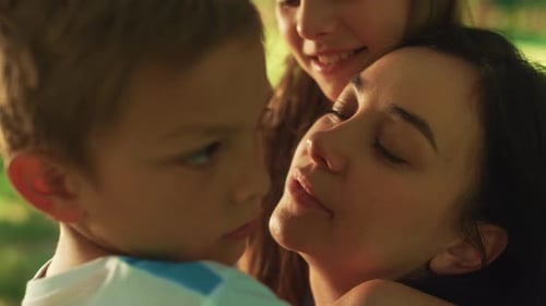 Fond Young Mother Kissing Cute Boy on Picnic Close Up. Happy Smiling