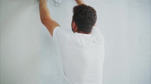 Man Applies Plaster to Wall During Home Renovation