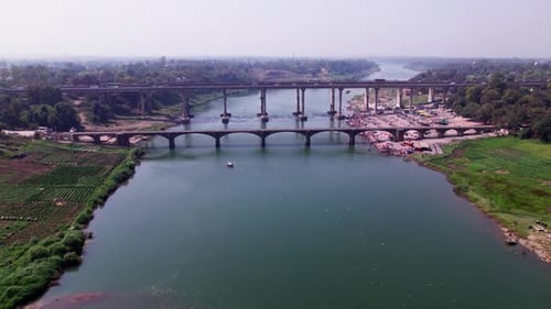 crop field lands with Tilwara Narmada River Bridge and flying birds at narmada ghat, tilwara, jabalp