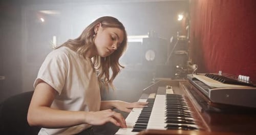 Woman Plays Keyboard in Foggy Studio
