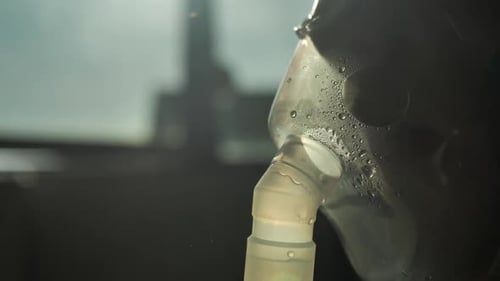 Gros plan d'un enfant portant un masque à oxygène en plastique sur son visage en inhalant ses poumons avec un nébuliseur