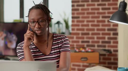 Young Woman Working at Home Talking on Phone