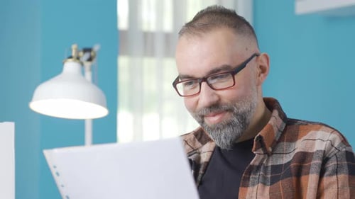 Man Reads Paper and Makes Fist Pumping Gesture