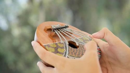 girl playing kalimba, also known as a thumb piano or mbira. African trdicional meditating
instrumen