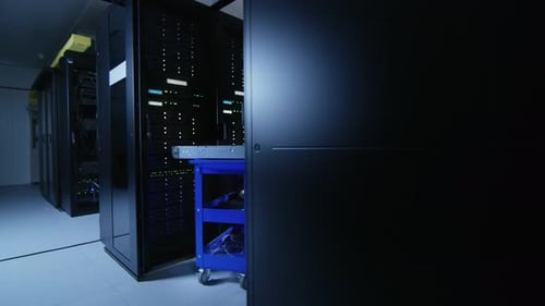 In the Modern Data Center: Team of IT Technicians Working with Server Racks, Running Maintenance an