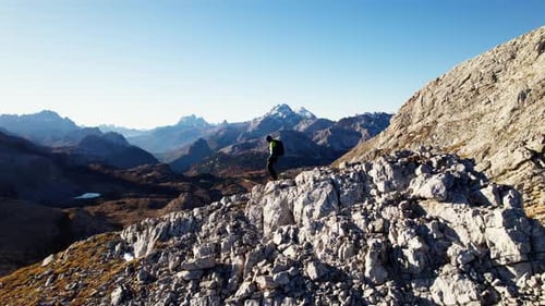 Hiker hiking downhill in the Dolomites in autumn.