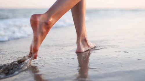 Slim Female Legs and Feet Walking Along Sea Water Waves on Sandy Beach Pretty Woman Walks at Seaside