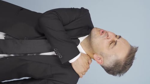 Man in Suit Massaging Sore Neck and Shoulder