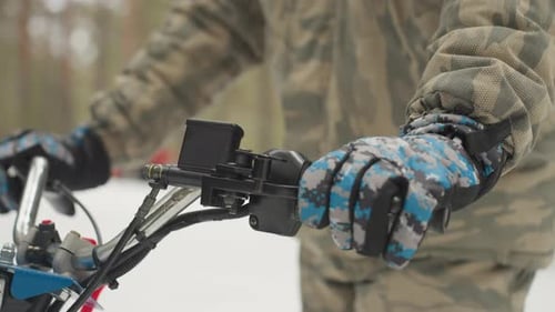 Winter ATV Control Adjusting Throttle and Camera on Snowy Forest Trail Insulated Gloves Securing
