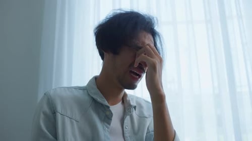 Man Crying In Front Of Window