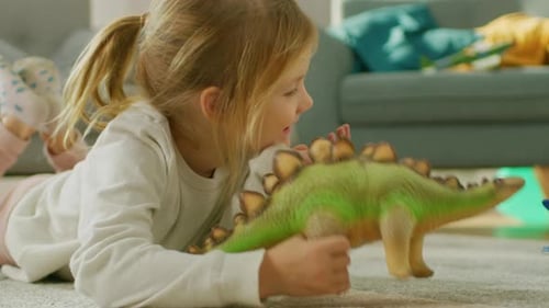 Happy Young Girl Playing with Dinosaur Toy