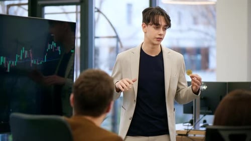 Young worker leading business meeting in an office, discussing the topic of cryptocurrencies with ot