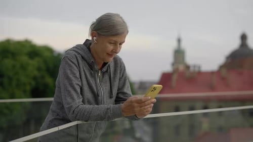 Woman Using Smartphone in City View