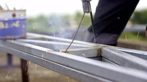 Electric arc welding with rod on steel metal construction, close up without gloves