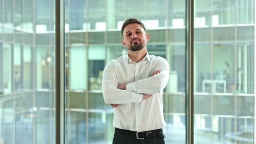 Confident Businessman in Modern Office with Arms Crossed