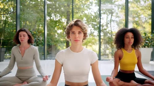 Group of Five Friends Gathering in Studio to Practice Yoga