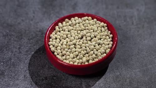 White Peppercorns in Red Bowl