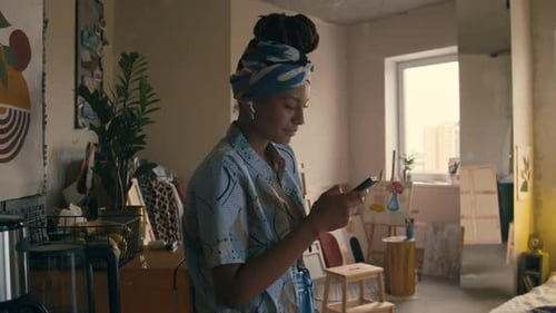 Artist Using Smartphone in Her Apartment Studio