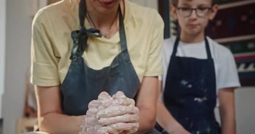 Mother with Kid Making Clay Pot in Workshop