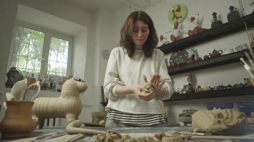 Caucasian Female Ceramist Working with Material in Workshop