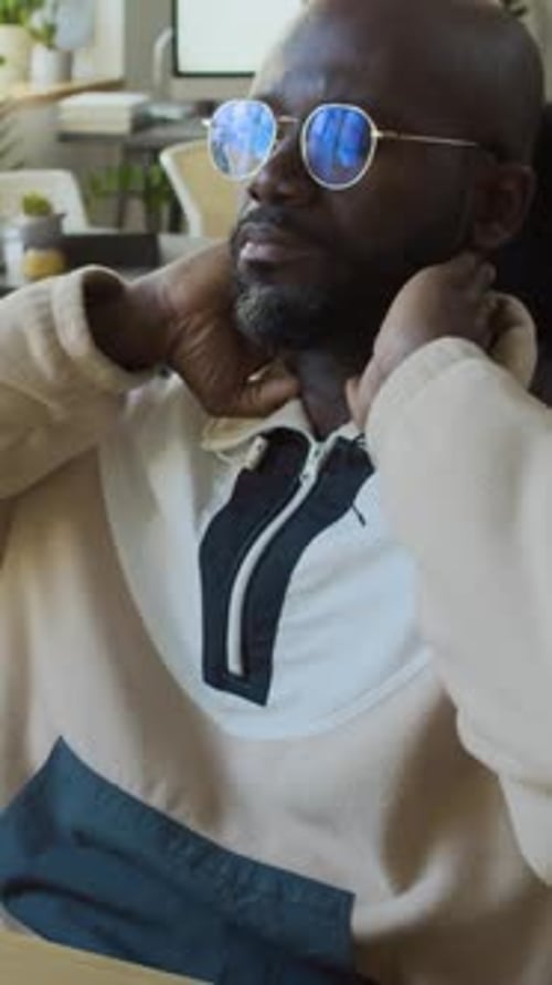 Tired Black Male Programmer Massaging Stiff Neck at Work