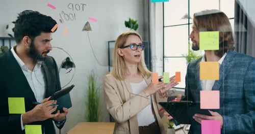 Team Discussing Strategy at Whiteboard in Modern Office