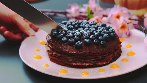 Chocolate Pancake Stack with Blueberries Being Cut