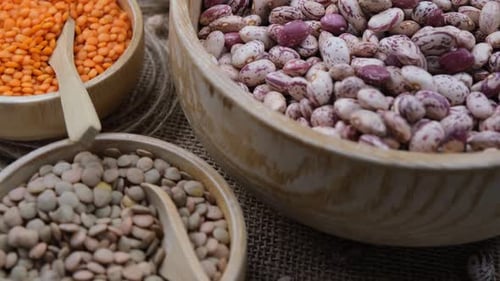 Assorted dry legumes in light wooden bowls
