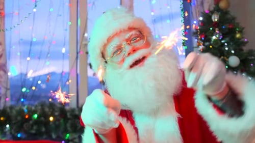 Close-up of a cheerful Santa Claus waving and dancing with sparklers in his hands