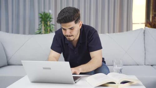 Young Adult Working on Laptop at Home