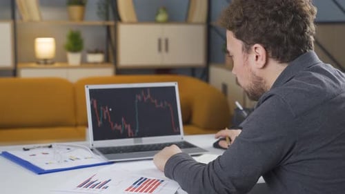 Man analyzing stock market, charts.